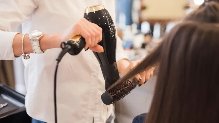 A stylist blow dries a client's hair after a consultation at Scarlette Rose Salon Abu Dhabi.